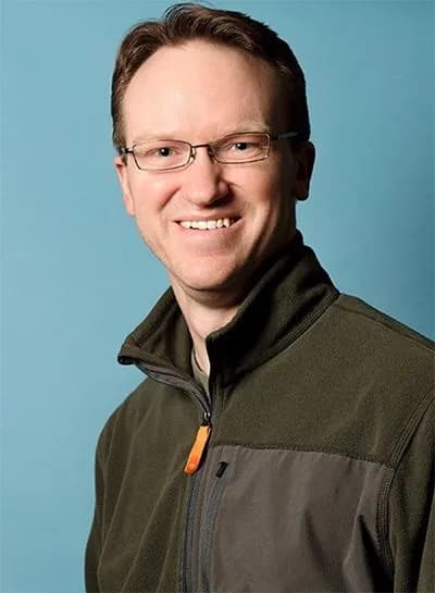 Dr. Alexander W. Smith smiling, wearing glasses and a fleece jacket.
